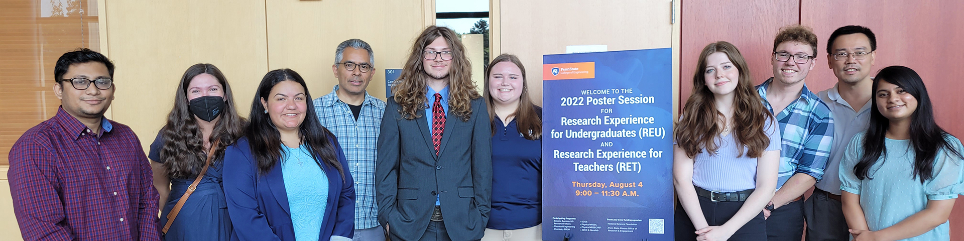 Students and faculty pose for a photo at a research fair.