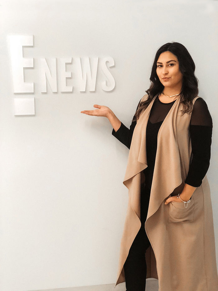 Catherine Rivera Chardon poses by the E! News logo during her internship