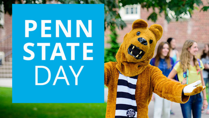 Nittany Lion hodling a Penn State Day sign
