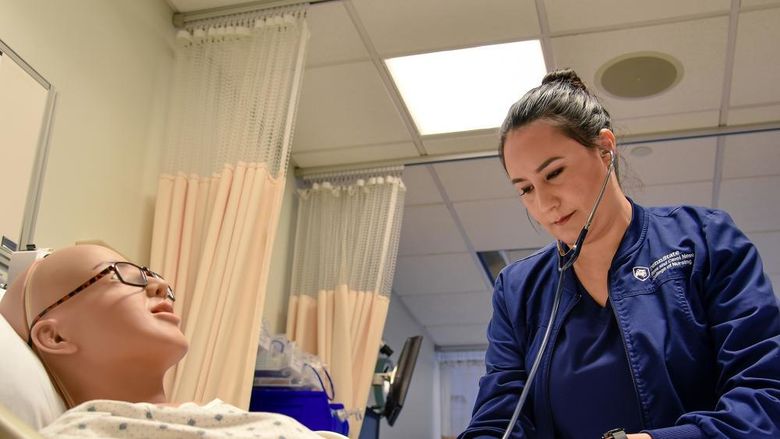 Paola Jaramillo Calderon interacts with a mannequin in Penn State Altoona's nursing simulation lab.