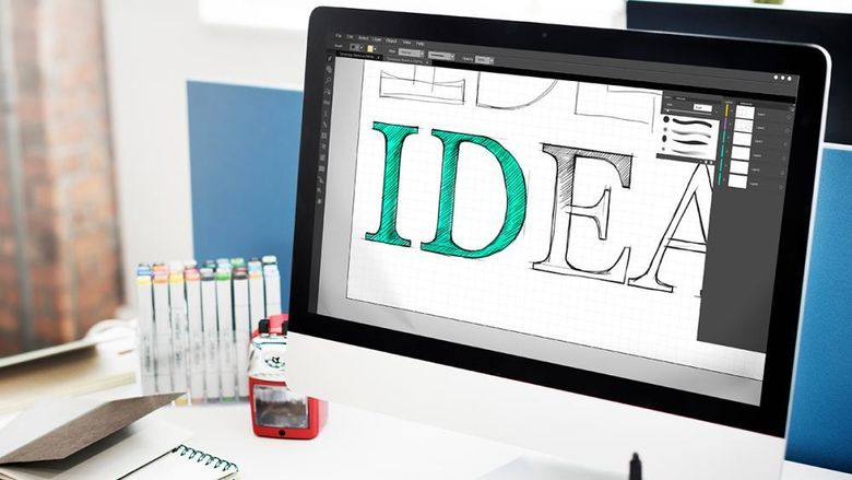 Image of a laptop with someone designing a logo of the word idea