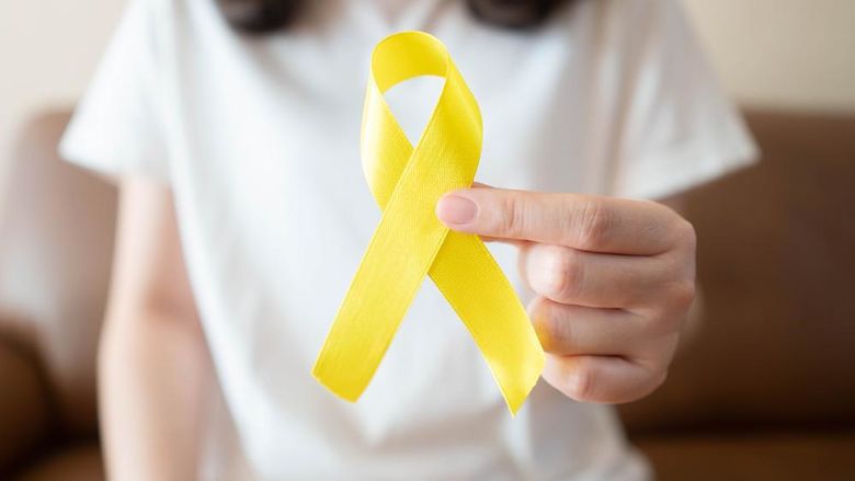 A girl holding a yellow ribbon symbolizing suicide prevention