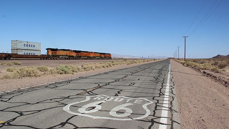 photo of US Route 66 with railroad in the background