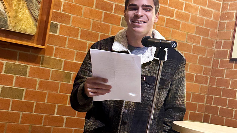 Student Evan Smith reads an original poem
