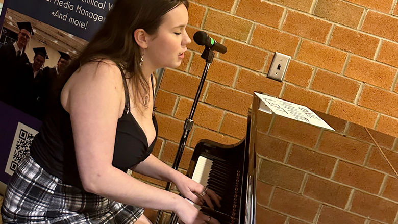 Student Maddy Colello performs an original song
