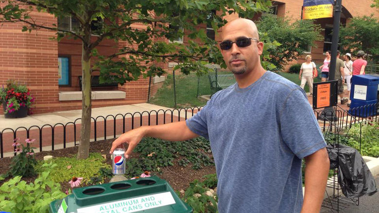 Coach James Franklin dropping a can into a recycle bin