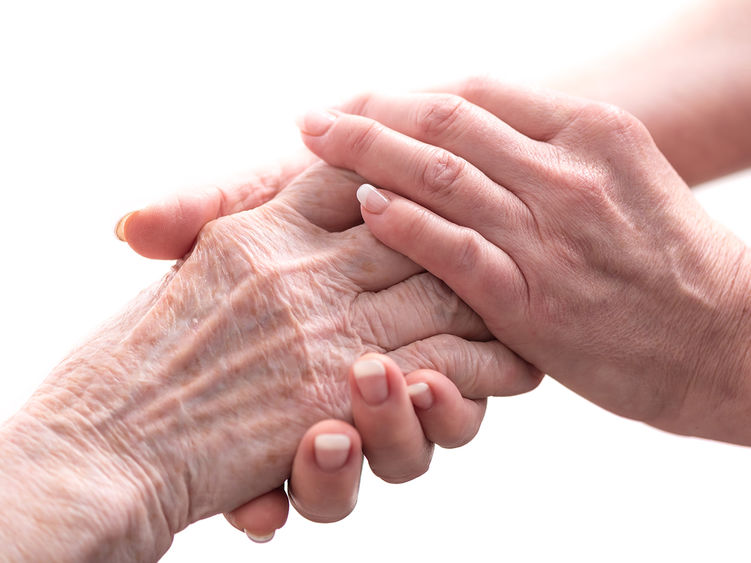 A pair of younger hands holding a pair of older hands