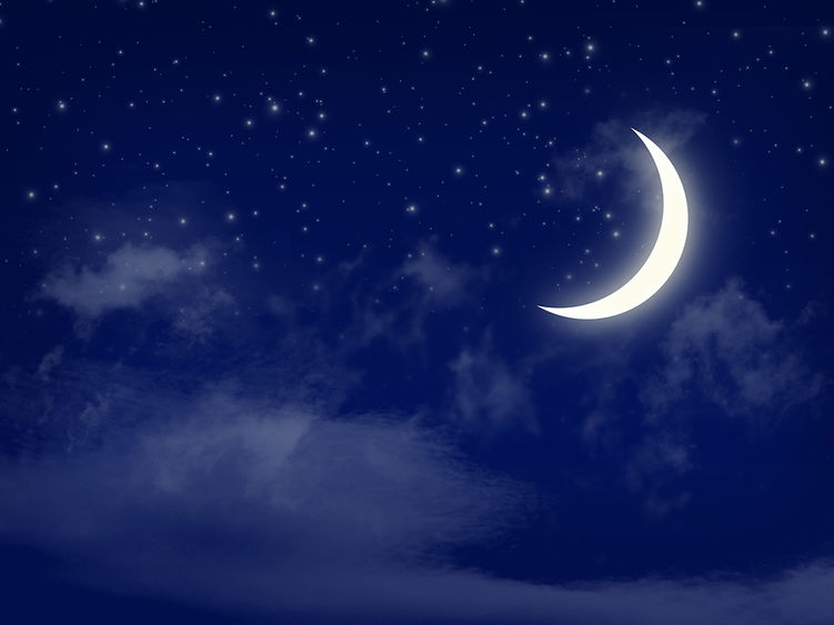 A crescent moon in a dark, blue sky