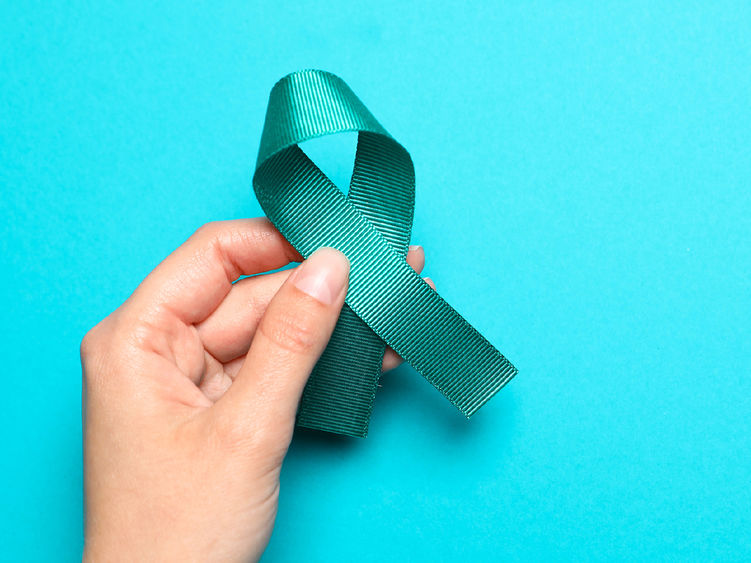 Woman holding teal awareness ribbon on light blue background, top view with space for text. Symbol of social and medical issues