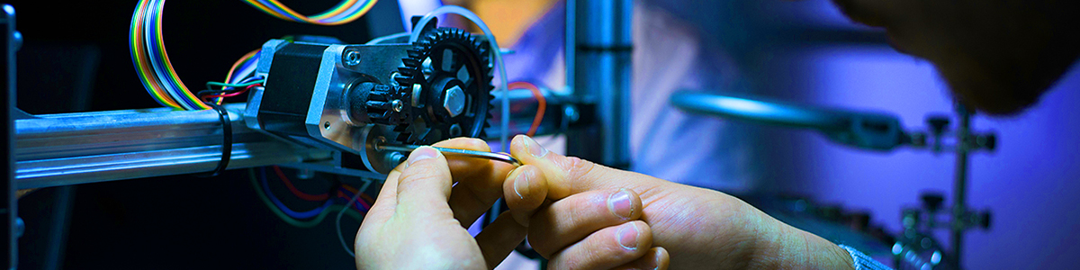 A photo of hands working on a robotics process