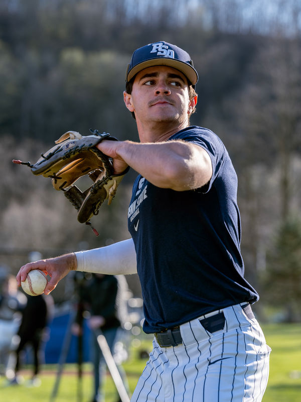 A Penn State Altoona baseball player throwing the ball during a practice session