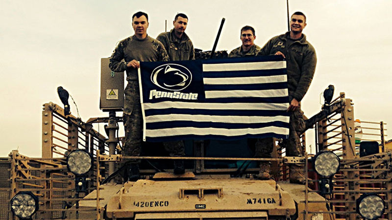From left to right, Johnathan Bucher(Alumni), Joshua Keele, Christian Cieslak, Shaun Aiken proudly display a Penn State flag while on tour in Afghanistan.