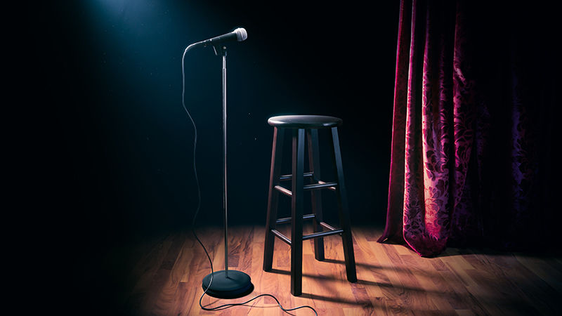A microphone and stool for a stand-up comedy performance