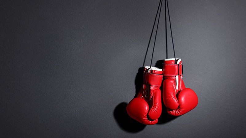A pair of black Boxing Gloves Hanging Against White Hanging Boxing ...