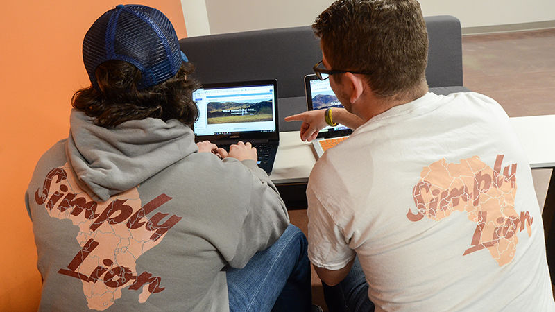 Logan McHale and Bill Butterfield working on their website and sporting their Simply Lion wear