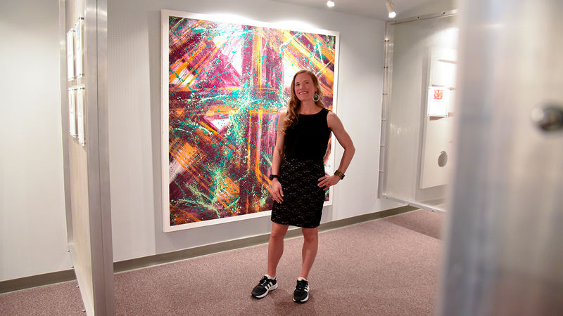 Heidi Manfred stands in front of her piece, Joyful, at the opening of her Emotions in Art exhibit.