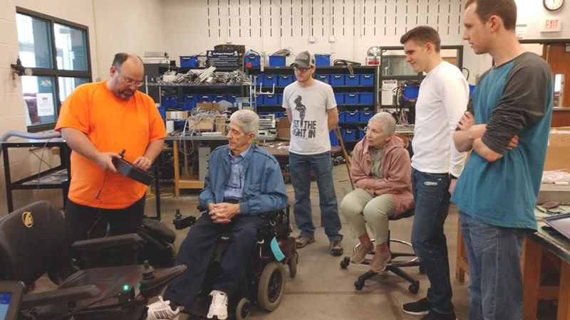 Brennecke and students demonstrate the automated wheelchair to Rich Harley