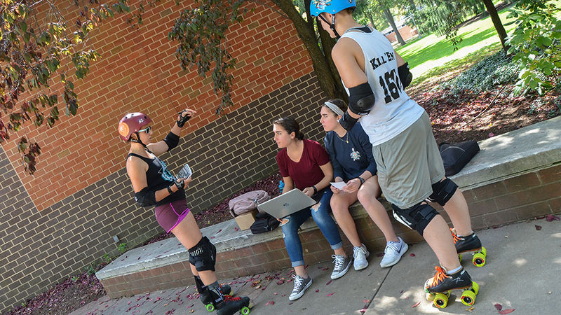 Rebecca Strzelec and Molly Kellom talk to others on campus about roller derby