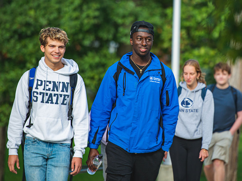 Students walking near the Penn State Altoona campus reflecting pond.