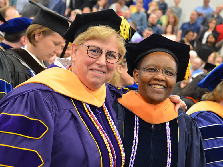 Two nursing professors pose at commencement ceremony