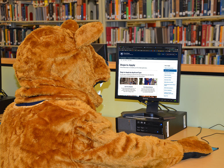 Nittany Lion on a computer applying to college