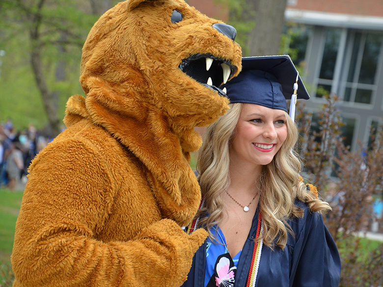 Nittany Lion mascot posing with recent graduate