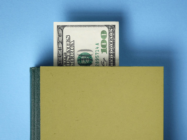 Money sticking out of a book like a bookmark