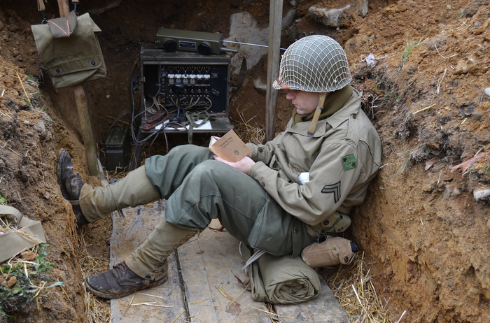 A WWII reenactor dressed as a soldier in a trench