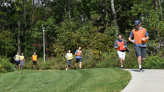 Kinesiology students running outside on campus