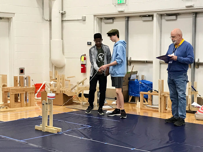 A pair of students compete in the 2023 PA Science Olympiad at Penn State Altoona while a judge observes