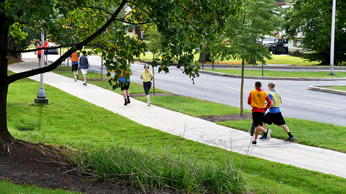 Kinesiology students running outside on campus