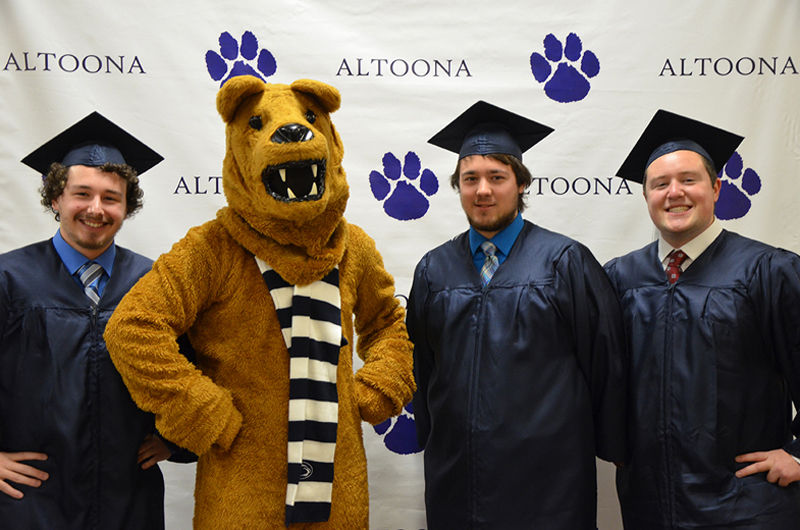Graduates pose with the Nittany Lion at Fall 2016 Commencement