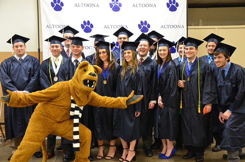 Graduates pose with the Nittany Lion at Fall 2016 Commencement