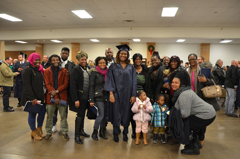 A graduate poses with her family after Fall 2016 Commencement ceremony