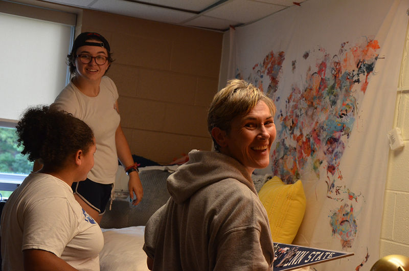 A first year student and their family decorate their residence hall room.