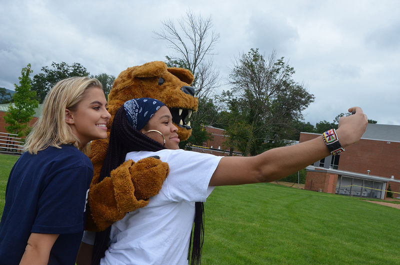 Students pose for a selfie with the Nittany Lion