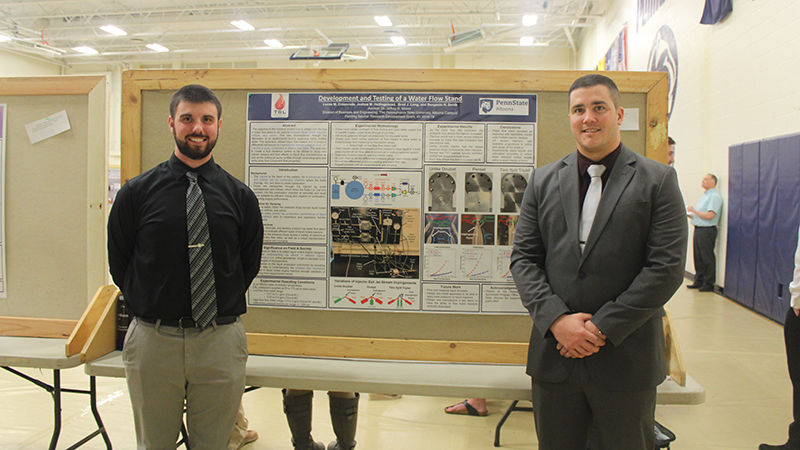 Student presenters Matthew Littler and Benjamin Smith pose for a photo in front of their poster presentation.