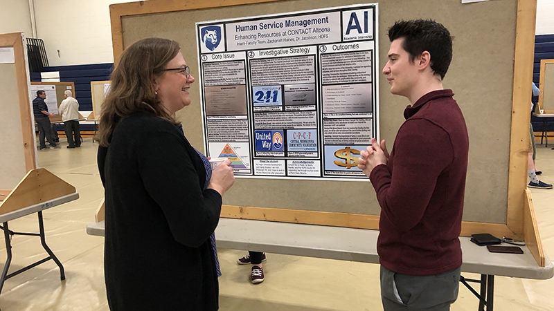 Student presenter Zachariah Haines chats with faculty member Melisaa Koehler