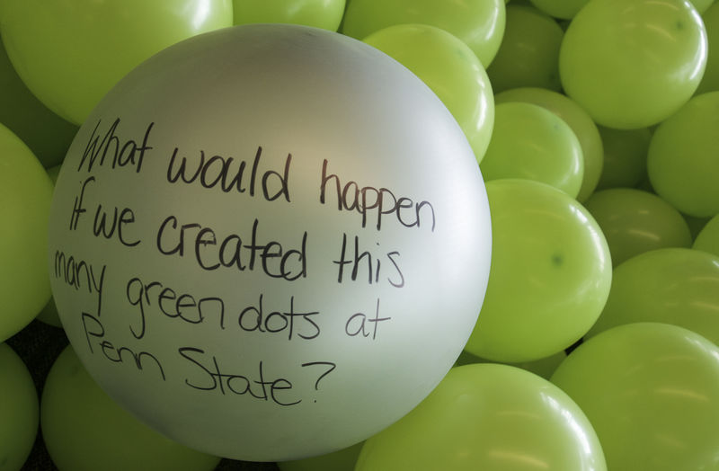 A balloon with the message "What would happen if we created this many green dots at Penn State?"