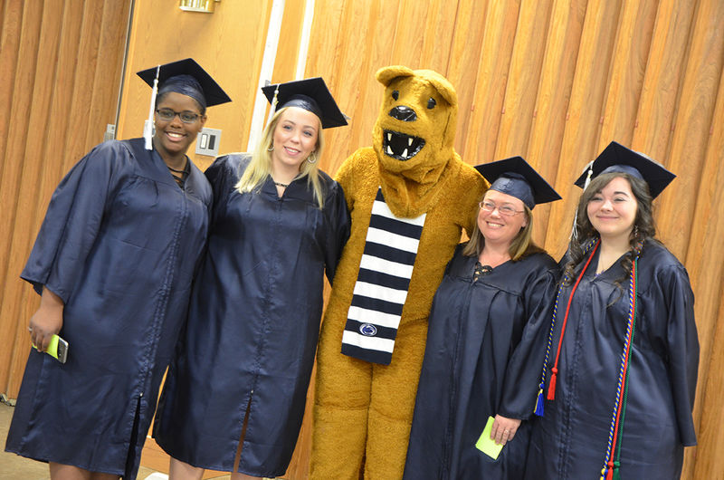 Graduates pose with the Nittany Lion at Fall 2017 Commencement ceremony.