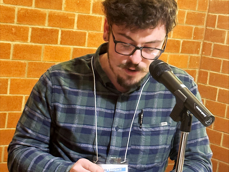 Student Aidan Pellegrino, editor-in-chief of Hard Freight, reads an original poem