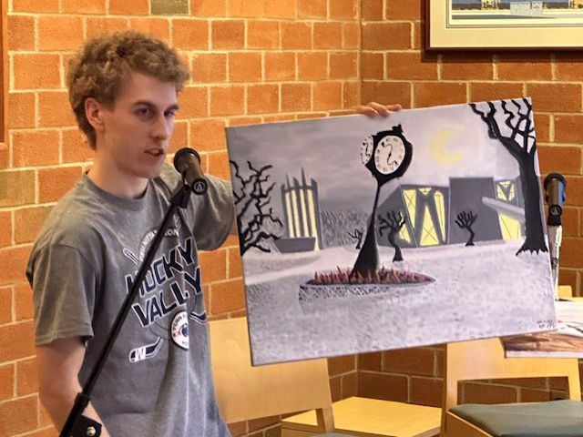 Student Talon McKendree displays an original painting of the Penn State Altoona campus in the style of German Expressionism.