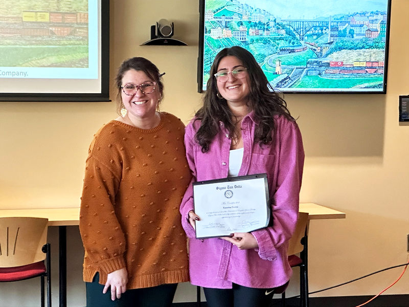 Katerina Poulos (right) is inducted into the Sigma Tau Delta English national honor society by Jeannette Lang, assistant teaching professor of English.