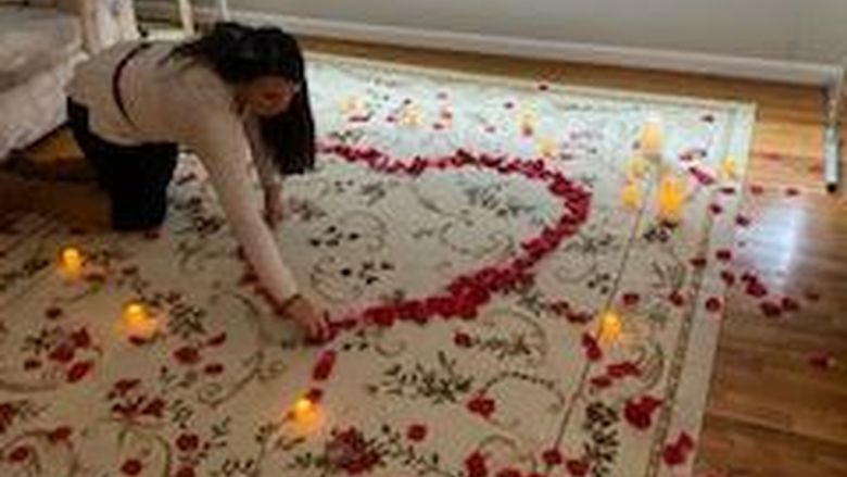 Beth Strange arranges rose petals in the shape of a heart