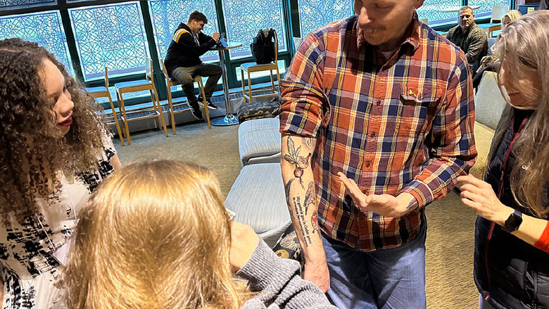 Students and faculty admire Professor Jeffery Stoyanoff's new tattoos.
