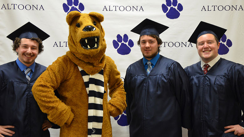 Graduates pose with the Nittany Lion at Fall 2016 Commencement