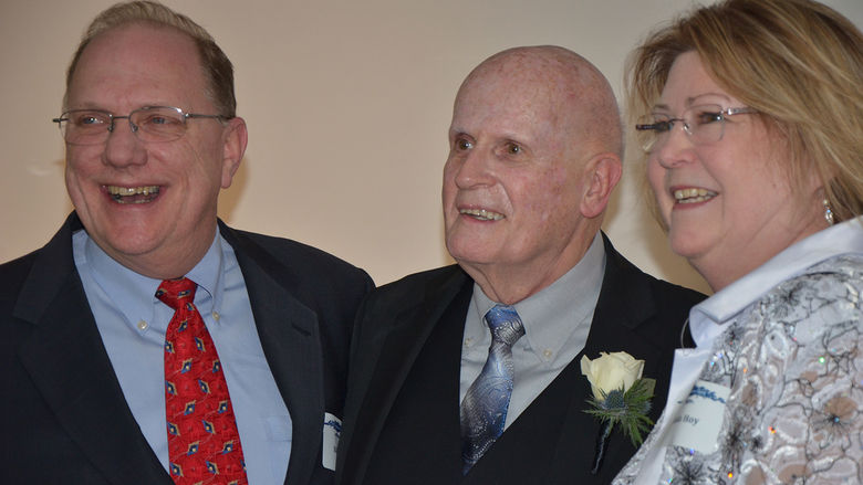 Two guests with honoree C. David Kimmel