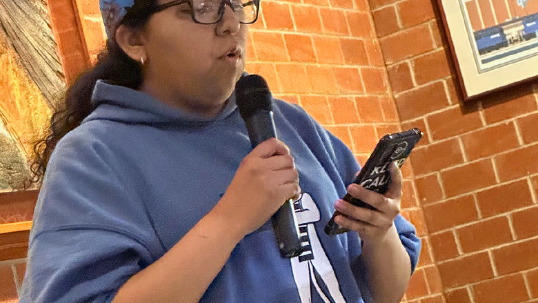 Student Alayna Mark reads an original poem.