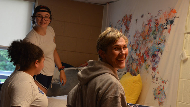 A first year student and their family decorate their residence hall room.