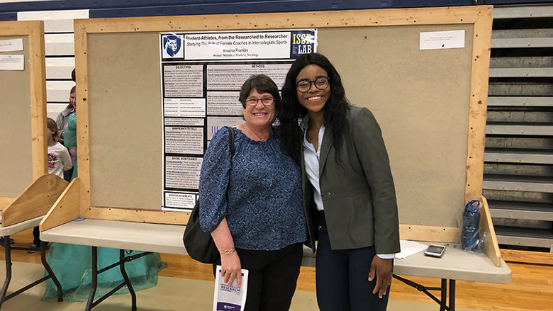 A student presenter poses for a photo with a faculty member